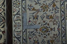 Backside of handmade 2000s Kashan rug showing knot structure and weave density