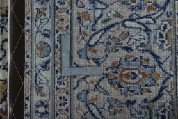 Backside of handmade 2000s Kashan rug showing knot structure and weave density