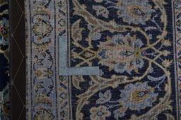 Backside of handmade 2000s Kashan rug showing knot structure and weave density