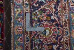 Backside of handmade 2000s Kashan rug showing knot structure and weave density