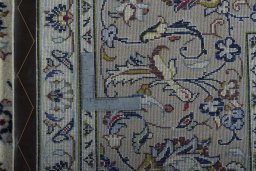 Backside of handmade 2000s Kashan rug showing knot structure and weave density