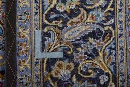 Backside of handmade 2000s Kashan rug showing knot structure and weave density