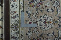 Backside of handmade 2000s Kashan rug showing knot structure and weave density