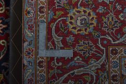 Backside of handmade New Kashan rug showing knot structure and weave density