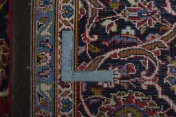 Backside of handmade 2000s Kashan rug showing knot structure and weave density