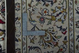 Backside of handmade 2000s Kashan rug showing knot structure and weave density