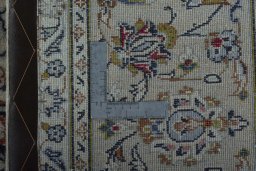 Backside of handmade 2000s Kashan rug showing knot structure and weave density