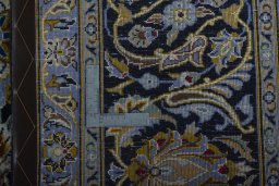 Backside of handmade 2000s Kashan rug showing knot structure and weave density