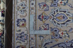 Backside of handmade 2000s Kashan rug showing knot structure and weave density