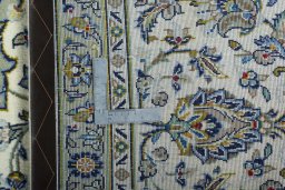Backside of handmade 2000s Kashan rug showing knot structure and weave density