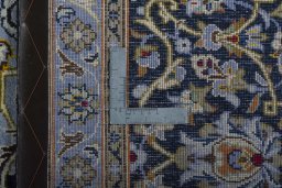 Backside of handmade 2000s Kashan rug showing knot structure and weave density