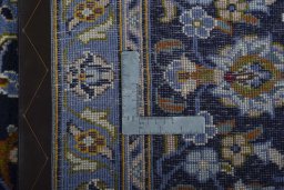Backside of handmade 2000s Kashan rug showing knot structure and weave density