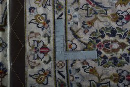 Backside of handmade 2000s Kashan rug showing knot structure and weave density