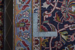 Backside of handmade 2000s Kashan rug showing knot structure and weave density