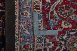 Backside of handmade 2000s Kashan rug showing knot structure and weave density