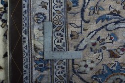 Backside of handmade 2000s Kashan rug showing knot structure and weave density