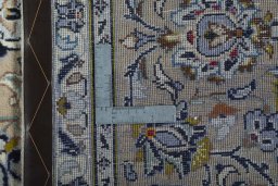 Backside of handmade 2000s Kashan rug showing knot structure and weave density