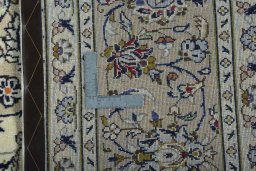 Backside of handmade 2000s Kashan rug showing knot structure and weave density