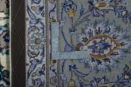 Backside of handmade 2000s Kashan rug showing knot structure and weave density