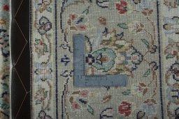 Backside of handmade 2000s Kashan rug showing knot structure and weave density