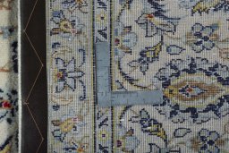 Backside of handmade 2000s Kashan rug showing knot structure and weave density