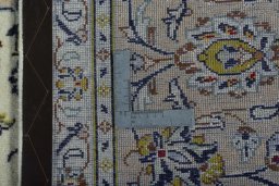 Backside of handmade 2000s Kashan rug showing knot structure and weave density