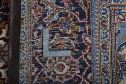 Backside of handmade 2000s Kashan rug showing knot structure and weave density
