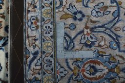 Backside of handmade 2000s Kashan rug showing knot structure and weave density