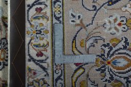 Backside of handmade 2000s Kashan rug showing knot structure and weave density