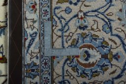 Backside of handmade 2000s Kashan rug showing knot structure and weave density