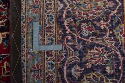 Backside of handmade 2000s Kashan rug showing knot structure and weave density