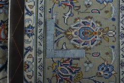 Backside of handmade 2000s Kashan rug showing knot structure and weave density