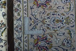 Backside of handmade 2000s Kashan rug showing knot structure and weave density