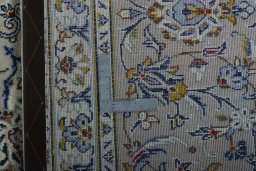Backside of handmade 2000s Kashan rug showing knot structure and weave density