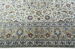 Corner detail of 2000s Kashan rug showing border pattern and Wool pile