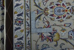 Backside of handmade 2000s Kashan rug showing knot structure and weave density