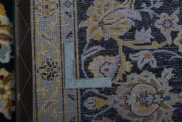 Backside of handmade 2000s Kashan rug showing knot structure and weave density