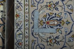 Backside of handmade 2000s Kashan rug showing knot structure and weave density
