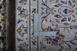 Backside of handmade 2000s Kashan rug showing knot structure and weave density