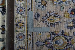Backside of handmade 2000s Kashan rug showing knot structure and weave density