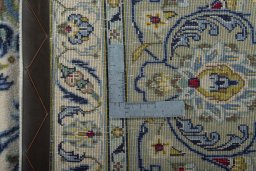Backside of handmade 2000s Kashan rug showing knot structure and weave density