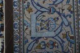 Backside of handmade 2000s Kashan rug showing knot structure and weave density