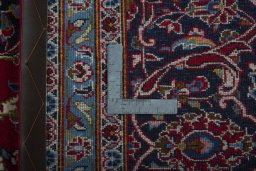 Backside of handmade 2000s Kashan rug showing knot structure and weave density