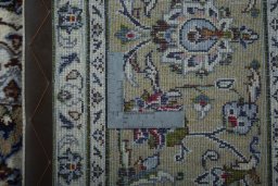 Backside of handmade 2000s Kashan rug showing knot structure and weave density