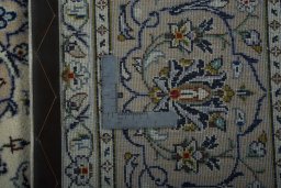 Backside of handmade 2000s Kashan rug showing knot structure and weave density