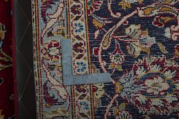 Backside of handmade 2000s Kashan rug showing knot structure and weave density