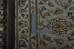 Backside of handmade 2000s Kashan rug showing knot structure and weave density