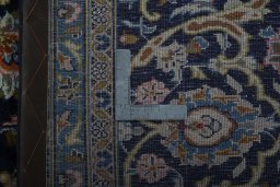 Backside of handmade 2000s Kashan rug showing knot structure and weave density