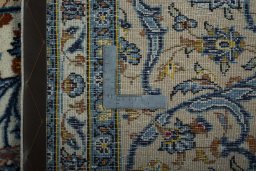 Backside of handmade 2000s Kashan rug showing knot structure and weave density