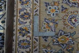 Backside of handmade 2000s Kashan rug showing knot structure and weave density